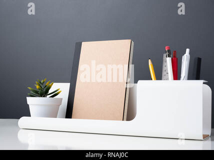 notebook on modern office stationery on white table.pencil, notepad,ruler,pen and pencil box with plant.Mock up paper note for display of design or co Stock Photo