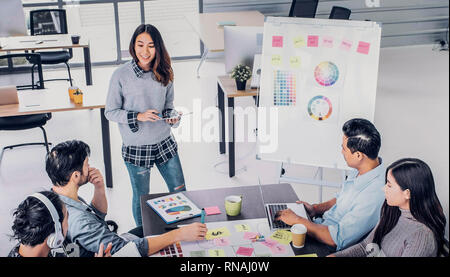 Female Creative director team lead brainstrom branding project with designer team at meeting table.discussion idea in creative office Stock Photo