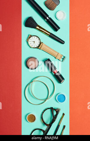 Top view of mascara, watch, lipstick, bracelets, eyeshadow, blush, glasses and cosmetic brushes Stock Photo