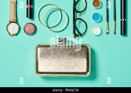 Top view of watch, lipstick, bracelets, glasses, eyeshadow, blush, clutch, cosmetic brushes and mascara Stock Photo