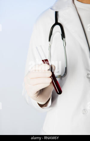 Cropped view of doctor with stethoscope holding test tube with blood Stock Photo