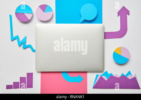 top view of paper charts and graphs, pointers, sheet of paper, closed laptop on white background Stock Photo