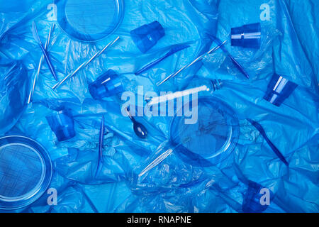 top view of blue crumpled polyethylene bag with plastic bottles, cups, plates, knives, spoon ang sponge Stock Photo
