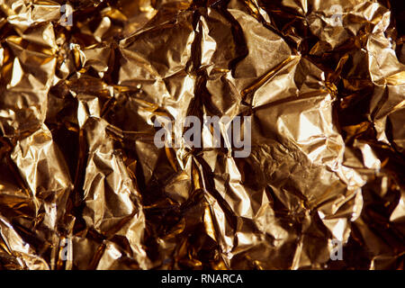 creased golden foil sheet with twinkles and shadows Stock Photo