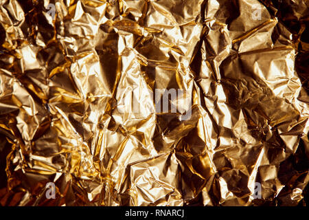 crumpled golden foil with shadows and twinkles Stock Photo