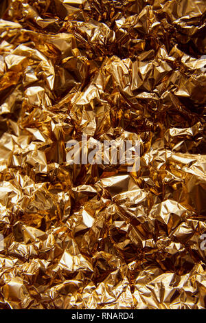 crumpled golden foil with glares and sparkles Stock Photo