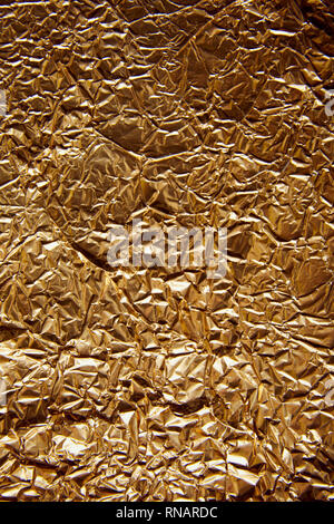 top view of rumpled sheet golden foil with glares Stock Photo