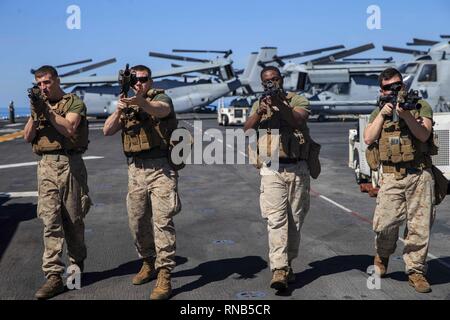 190215-M-YD783-1026 ARABIAN SEA (Feb. 15, 2019) U.S. Marines with the 22nd Marine Expeditionary Unit perform an assaulting fire drill on the flight deck of the Wasp-class amphibious assault ship USS Kearsarge (LHD-3). The Marines with Alpha Company, 1st Battalion, 2nd Marine Regiment practiced the drill to advance their skills for combat. Marines and Sailors with the 22nd MEU and Kearsarge Amphibious Ready Group are deployed to the 5th Fleet area of operations in support of naval operations to ensure maritime stability and security in the Central Region, connecting the Mediterranean and the Pa Stock Photo