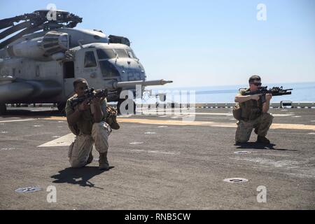 ARABIAN SEA (Feb. 15, 2019) U.S. Marines with the 22nd Marine Expeditionary Unit perform an assaulting fire drill on the flight deck of the Wasp-class amphibious assault ship USS Kearsarge (LHD-3). The Marines with Alpha Company, 1st Battalion, 2nd Marine Regiment practiced the drill to advance their skills for combat. Marines and Sailors with the 22nd MEU and Kearsarge Amphibious Ready Group are deployed to the 5th Fleet area of operations in support of naval operations to ensure maritime stability and security in the Central Region, connecting the Mediterranean and the Pacific through the we Stock Photo