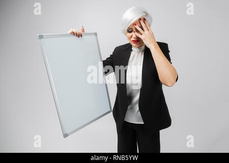 young girl with a magnetic Board in her hands stands isolated on a light background Stock Photo