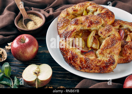 close-up of delicious open apple pies, galettes with apple slices sprinkled with sugar on a white platter. apple, cinnamon sticks, brown sugar and kit Stock Photo