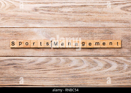 sports management word written on wood block. sports management text on wooden table for your desing, concept. Stock Photo