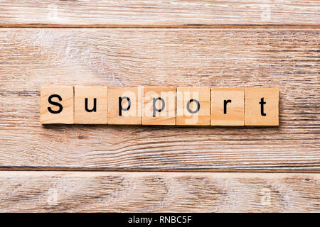 Support word written on wood block. Support text on wooden table for your desing, concept. Stock Photo