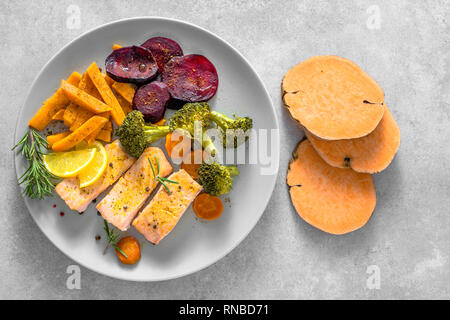 Gourmet food with cooked vegetable and baked salmon on plate. Dinner with fish and mixed vegetables. Stock Photo