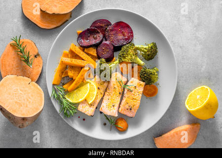 Dietary dish with grilled salmon and vegetables baked in oven Stock Photo