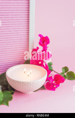pink ceramic bowl with candle, and pink flower, on a pink background Stock Photo