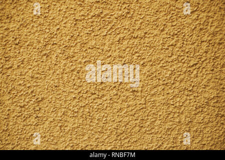 Concrete orange painted rugged, plastered wall Stock Photo