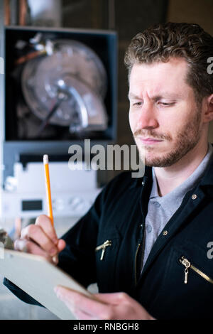 Male Plumber With Clipboard Installing Central Heating Boiler Stock Photo