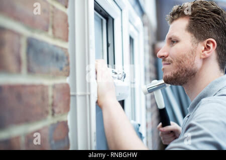 Construction Worker Installing New Windows In House Stock Photo