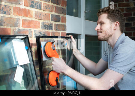Construction Worker Preparing To Fit Glass Into New Windows Stock Photo