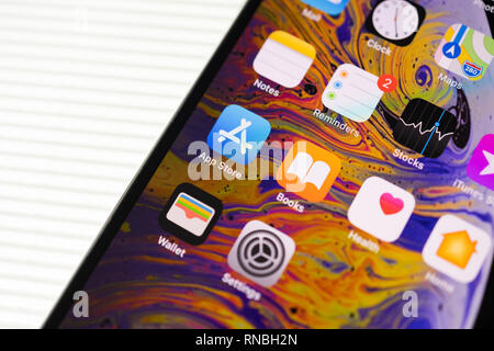 PARIS, FRANCE - SEP 27, 2018: new iPhone Xs Max smartphone model by Apple Computers close up with all home apps placed in 45 degrees on stripes white background - app store, books, reminders, motes, wallert, settings, stocks, maps clock apps Stock Photo