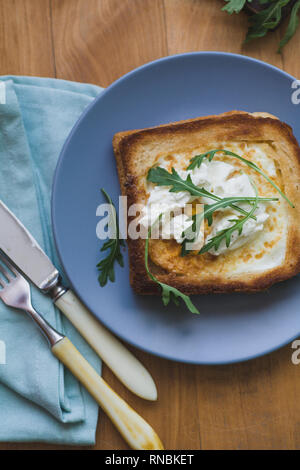 sandwich with egg and arugula on a plate is on the table Stock Photo