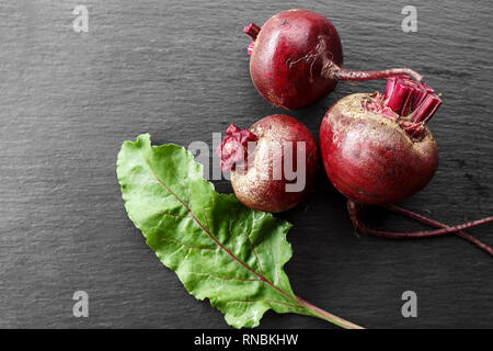 whole young beets on the table, on a black background. space for text Stock Photo