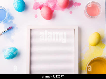 Painted eggs flat lay on a white background. Easter and spring composition. Copy space. Stock Photo