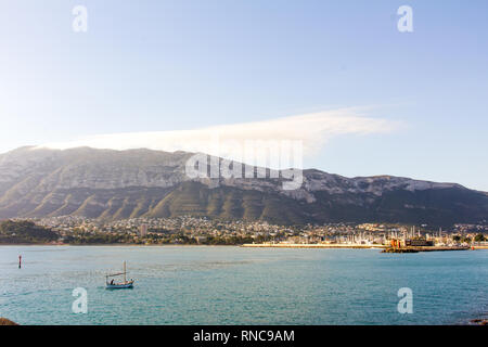 A small fishing boat entering the port in Denia, Spain. Montgó mountain is in the background Stock Photo