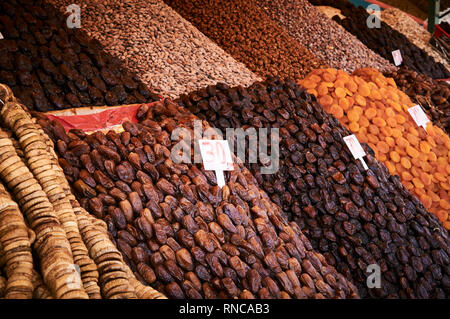 Piles of dried fruit and nuts for sale in a souq in the medina of Marrakech. Dried figs, apricots, dates, sultanas, nuts on sale in a market stall. Stock Photo