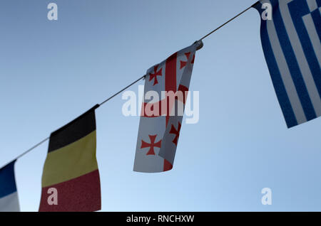 On the rope hangs the flag of Malta and a few flags on the background of the blue sky Stock Photo