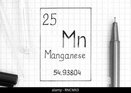 The Periodic table of elements. Handwriting chemical element Manganese Mn with black pen, test tube and pipette. Close-up. Stock Photo