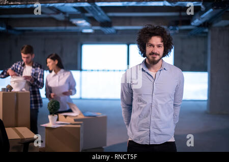 portrait of young businessman on construction site checking documents and business workflow with colleagues in the background in new startup office Stock Photo