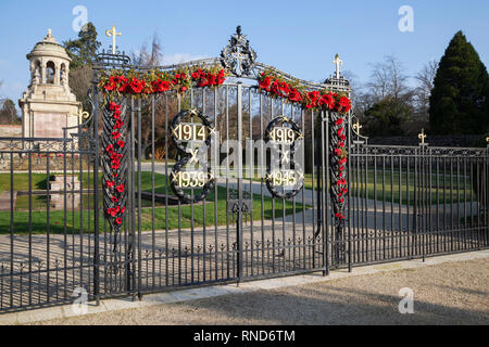 The war memorial gates with red poppies and dates of first and second world wars with the war memorial behind, in Helensburgh, Argyll, Scotland. Stock Photo