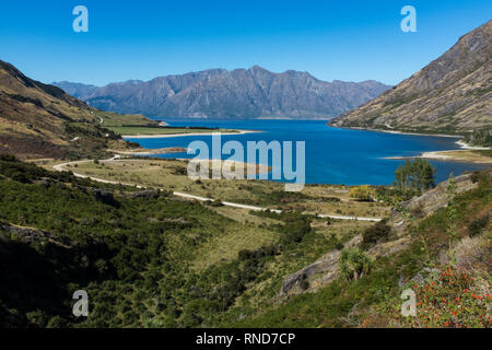 Wide view of Lake Hawea in New Zealand, brillant blue sky, ranges in the background Stock Photo