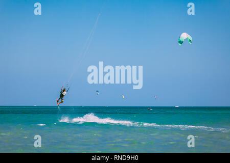 Egypt, Hurghada - 30 November, 2017: The kiteboarder surfing over the Red sea surface. The controllable power kite above the transparent water. Extrem Stock Photo