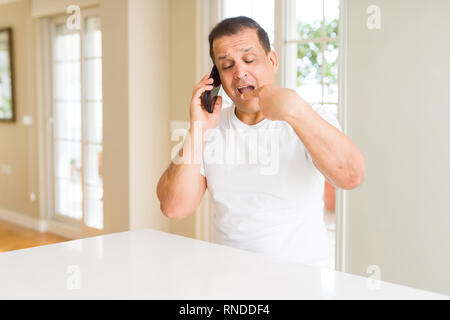 Middle age man calling using smartphone very happy pointing with hand and finger Stock Photo