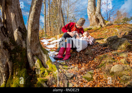 Young couple with traditional clothes on the natural forest in Carpathians Mountains - fall in love, youth and spring sunny day Stock Photo