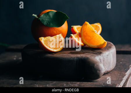 Fresh cut oranges on dark moody background Stock Photo