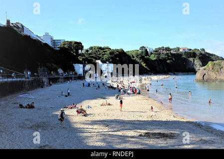Tenby, Pembrokeshire, South Wales, UK. July 25, 2018.  Tourists and holidaymakers enjoying the North beach and sea at high tide in July at Tenby in So Stock Photo