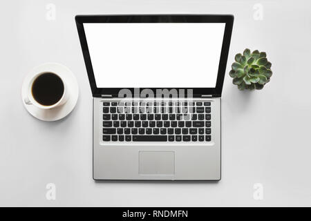 Open laptop, coffee, plant on office table. Top view wiyh space for text on screen. Stock Photo