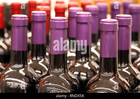 Wine bottles in a row, selective focus. Liquor store, red wine production concept Stock Photo