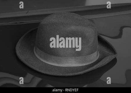 Old black hat on the black background. Stock Photo