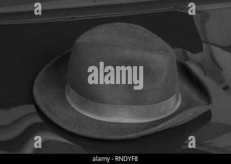 Old black hat on the black background. Stock Photo