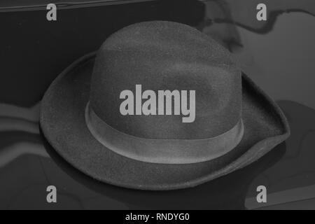 Old black hat on the black background. Stock Photo