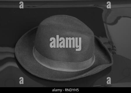 Old black hat on the black background. Stock Photo