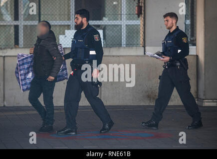 Frankfurt, Germany. 18th Feb, 2019.  Policemen accompany a man (l) to a terminal at the airport, from where he is to be deported to Afghanistan with a chartered plane in the evening. Photo: Boris Roessler/dpa - ATTENTION: The person was pixelated for reasons of personality rights Credit: dpa picture alliance/Alamy Live News Stock Photo