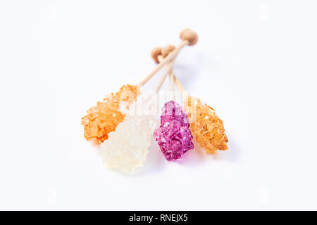 Rock candy or orange, white and purple sugar candy isolated on white background. Crystallized sugar. Nabat or rock candy is often used as a type of ca Stock Photo