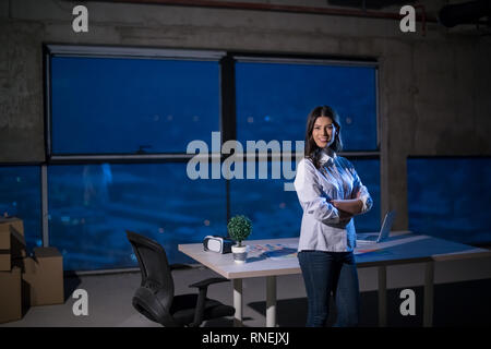 portrait of young female architect on construction site checking documents and business workflow using laptop computer in new startup office Stock Photo