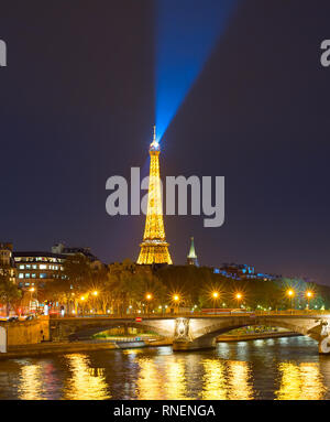 PARIS, FRANCE - OVEMBER 10, 2018: Siene river embankment and Eiffel Tower with spotlight at night in Paris. Stock Photo